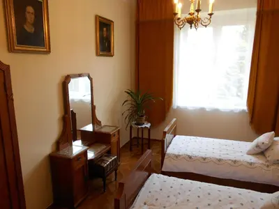 a bedroom with two beds and a mirror and a window at Apartament Krakowski Styl in Kraków