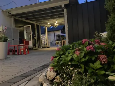 a patio with a black fence and pink flowers at Bed&Breakfast Mikunda in Chrzanów