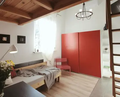 a bedroom with a bed and a red door at Bed&Breakfast Mikunda in Chrzanów