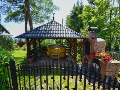 a gazebo with a fireplace and a barrel at domek simonka zawoja in Zawoja