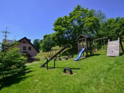a park with a playground with slides and a play structure at domek simonka zawoja in Zawoja