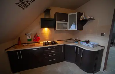 a kitchen with black cabinets and a sink at domek simonka zawoja in Zawoja
