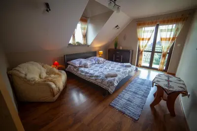 a bedroom with a bed and a couch at domek simonka zawoja in Zawoja