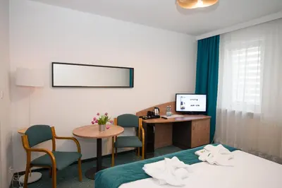 a hotel room with two beds and a desk at Zacisze Nad Nidą Resort in Pińczów