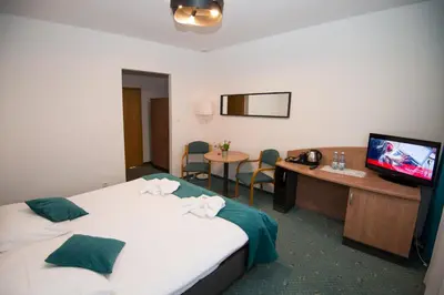 a hotel room with a bed and a desk and a television at Zacisze Nad Nidą Resort in Pińczów