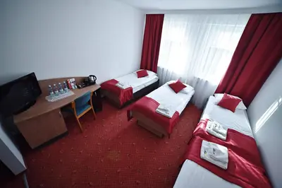 a hotel room with two beds and a television at Zacisze Nad Nidą Resort in Pińczów
