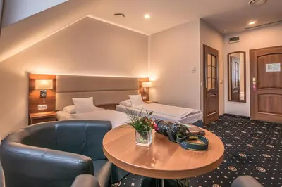 a hotel room with a bed and a table at ParkHotel Łysoń in Inwałd