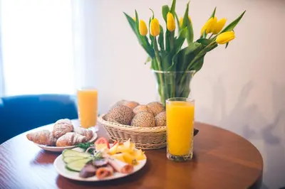 a table topped with plates of food and orange juice at ParkHotel Łysoń in Inwałd