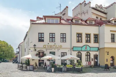 a large white building with umbrellas in front of it at Apartamenty Józefa Kazimierz in Kraków