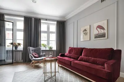 a living room with a red couch and a chair at Apartamenty Józefa Kazimierz in Kraków