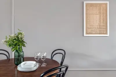 a dining room table with wine glasses and a menu on the wall at Apartamenty Józefa Kazimierz in Kraków