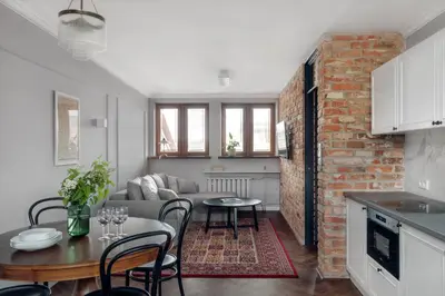 a kitchen and living room with a brick wall at Apartamenty Józefa Kazimierz in Kraków
