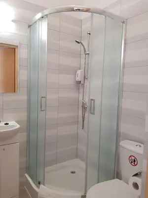 a glass shower in a bathroom with a toilet at Pokoje U Filipa in Kraków