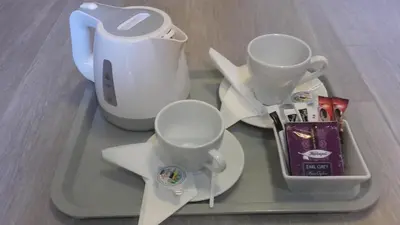 a tray with two cups and a tea pot on it at Pokoje U Filipa in Kraków