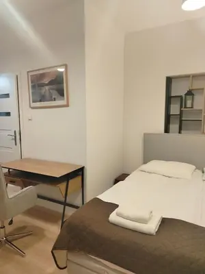 a bedroom with a bed and a desk and a chair at Pokoje U Filipa in Kraków