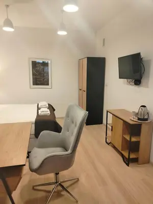 a room with a chair and a desk and a television at Pokoje U Filipa in Kraków