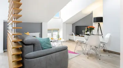 a living room with a gray couch and a table at Topolowa Apartment, next to Main Station in Kraków