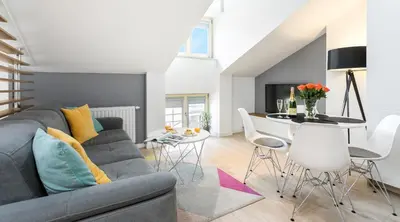 a living room with a gray couch and a table at Topolowa Apartment, next to Main Station in Kraków