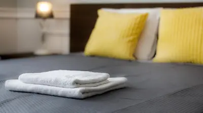 a pile of towels sitting on top of a bed at Topolowa Apartment, next to Main Station in Kraków