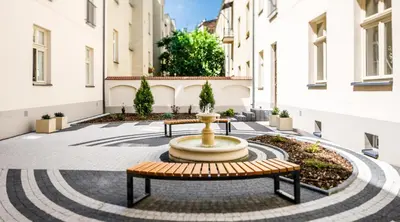 a courtyard with two benches and a fountain at Topolowa Apartment, next to Main Station in Kraków