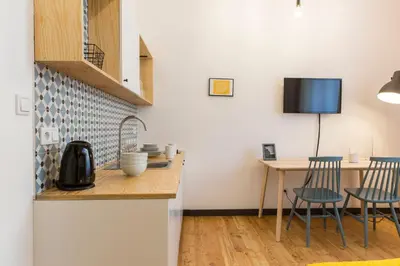 a kitchen with a counter and a table with chairs at 19Rooms in Kraków