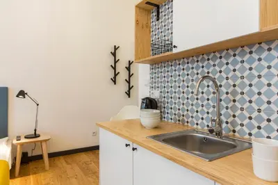 a kitchen with a sink and a lamp on a counter at 19Rooms in Kraków