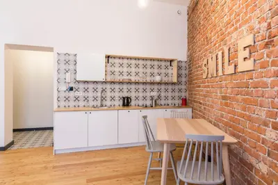 a kitchen with a brick wall and a table and chairs at 19Rooms in Kraków