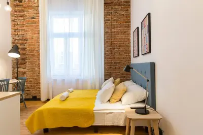 a bedroom with a bed with a yellow blanket at 19Rooms in Kraków