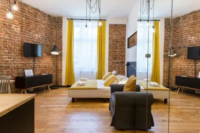 a living room with a couch and a brick wall at 19Rooms in Kraków