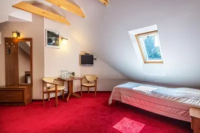 a bedroom with a bed and a table with chairs at Pokoje na stoku Czarny Groń in Rzyki