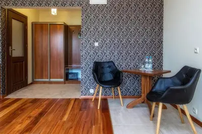 a living room with two chairs and a table at Pokoje na stoku Czarny Groń in Rzyki