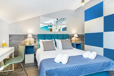 a bedroom with a large bed with blue and white walls at Krakow Central Apartments in Kraków