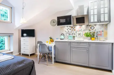 a room with a kitchen and a bed and a table at Krakow Central Apartments in Kraków