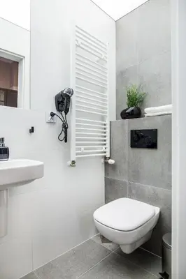 a white bathroom with a toilet and a sink at Krakow Central Apartments in Kraków