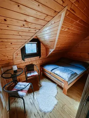 a bedroom with a bed in a wooden cabin at Domki,,Chatki Góralskie 