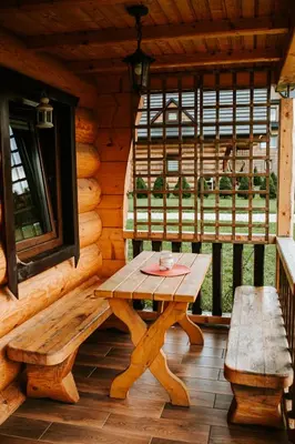 a wooden table and bench on the porch of a log cabin at Domki,,Chatki Góralskie 