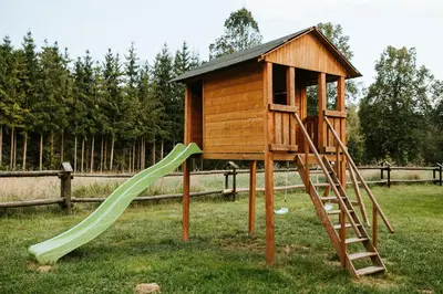 a small wooden play structure with a slide at Domki,,Chatki Góralskie 