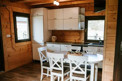 a kitchen with a table and chairs in a cabin at Domki,,Chatki Góralskie 