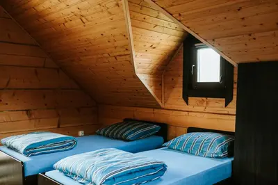 two beds in a room with a wooden attic at Domki,,Chatki Góralskie 