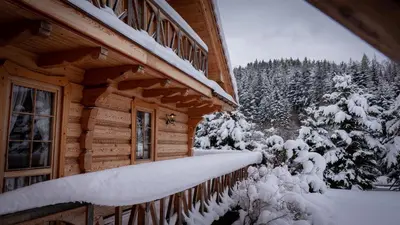 a log cabin with snow on the side of it at Jaśkowa Chata in Stryszawa