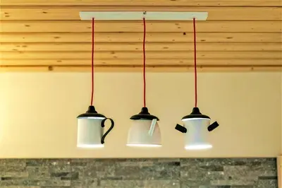 three lights hanging over a kitchen counter with pots and pans at Apartamenty 58 Czarny Groń in Rzyki