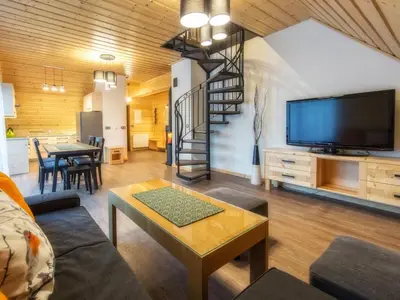a living room with a couch and a tv and a table at Apartamenty 58 Czarny Groń in Rzyki