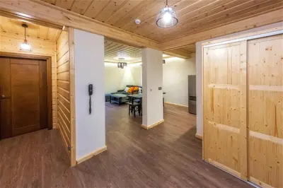 a hallway with wooden doors and a dining room at Apartamenty 58 Czarny Groń in Rzyki