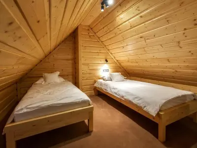 two beds in a room with wooden walls at Apartamenty 58 Czarny Groń in Rzyki