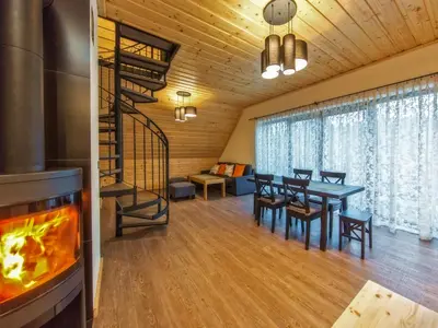 a dining room with a fireplace and a dining table at Apartamenty 58 Czarny Groń in Rzyki
