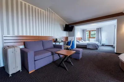 a hotel room with a couch and a bed at Hotel Beskidzki Raj Medical SPA in Stryszawa