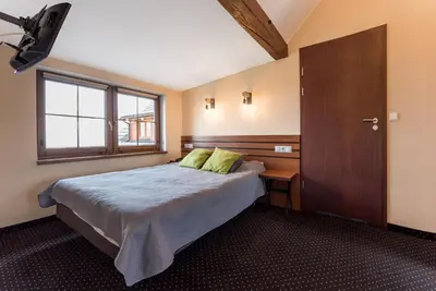 a bedroom with a bed and a window and a door at Hotel Beskidzki Raj Medical SPA in Stryszawa