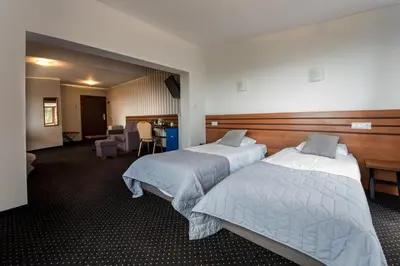 a hotel room with two beds and a desk at Hotel Beskidzki Raj Medical SPA in Stryszawa