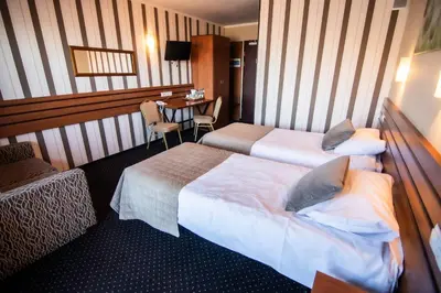a hotel room with two beds and a table at Hotel Beskidzki Raj Medical SPA in Stryszawa