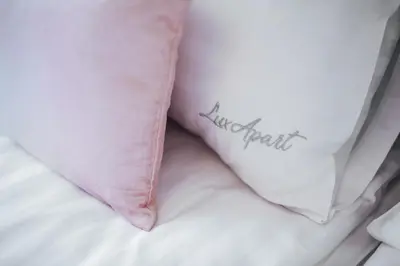 a pillow with the word awkward written on it on a bed at Szpitalna 20 Apartment 3 in Kraków